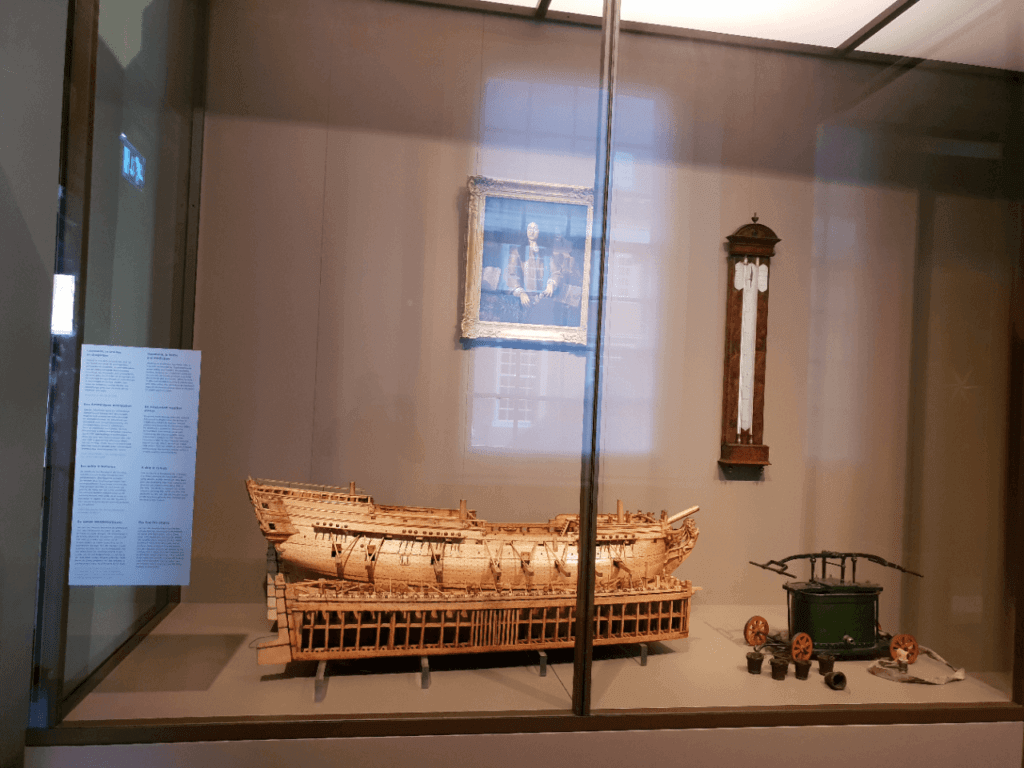 A replica of a ship, the first thermometer and first fire engine in Amsterdam. On the wall is a picture of Daniel Gabriel Fahrenheit on display at the Amsterdam Museum.